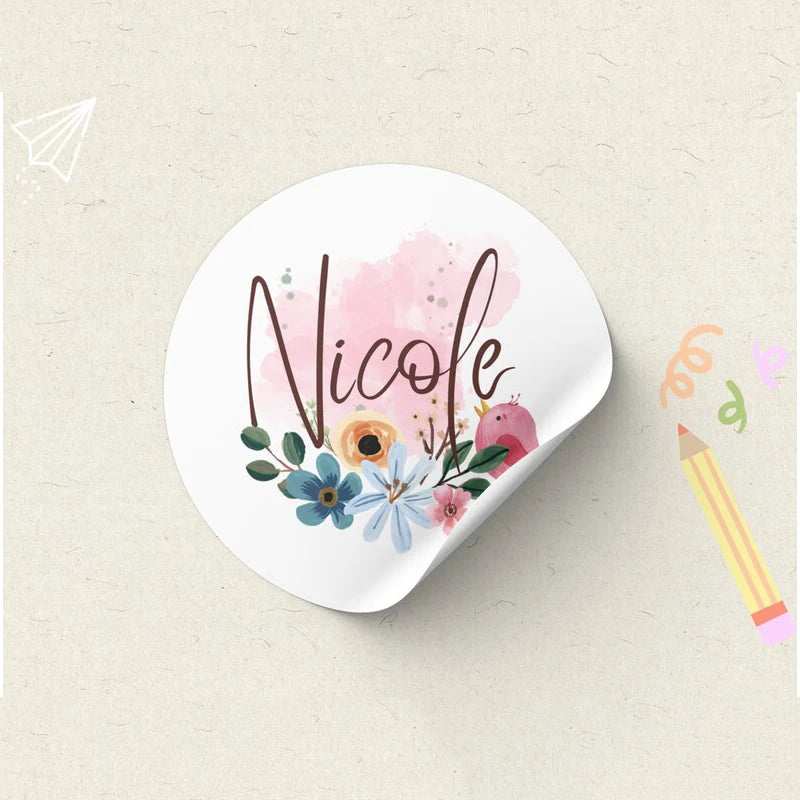 A white sticker featuring the name Nicole written in elegant script surrounded by pink and blue floral elements.
