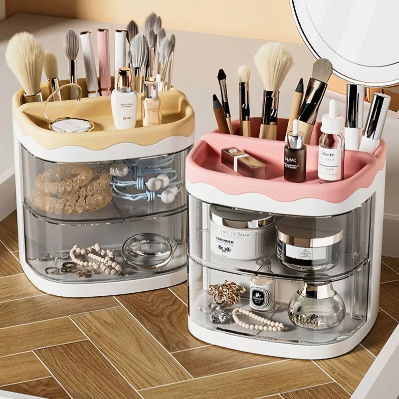 A clear acrylic desktop organizer holding various makeup brushes, pens, and cosmetic bottles in pink and gold tones.