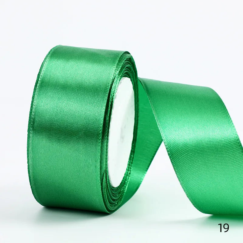 A roll of emerald green satin ribbon used for gift wrapping and DIY crafts.