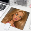 A realistic blonde doll face printed on a mouse pad for a desk, featuring large eyes and soft hair.