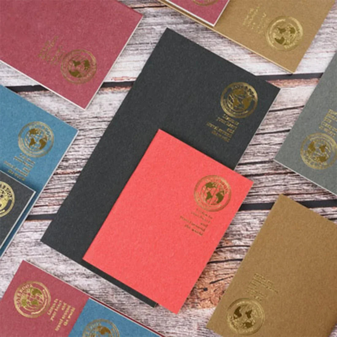A collection of retro gold foil inserts in various shades of pink, green, and gold resting on a wooden surface.