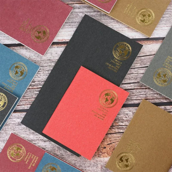 Eine Sammlung von Retro-Goldfolie-Inserts in verschiedenen Rosa-, Grün- und Goldtönen auf einer Holzoberfläche.