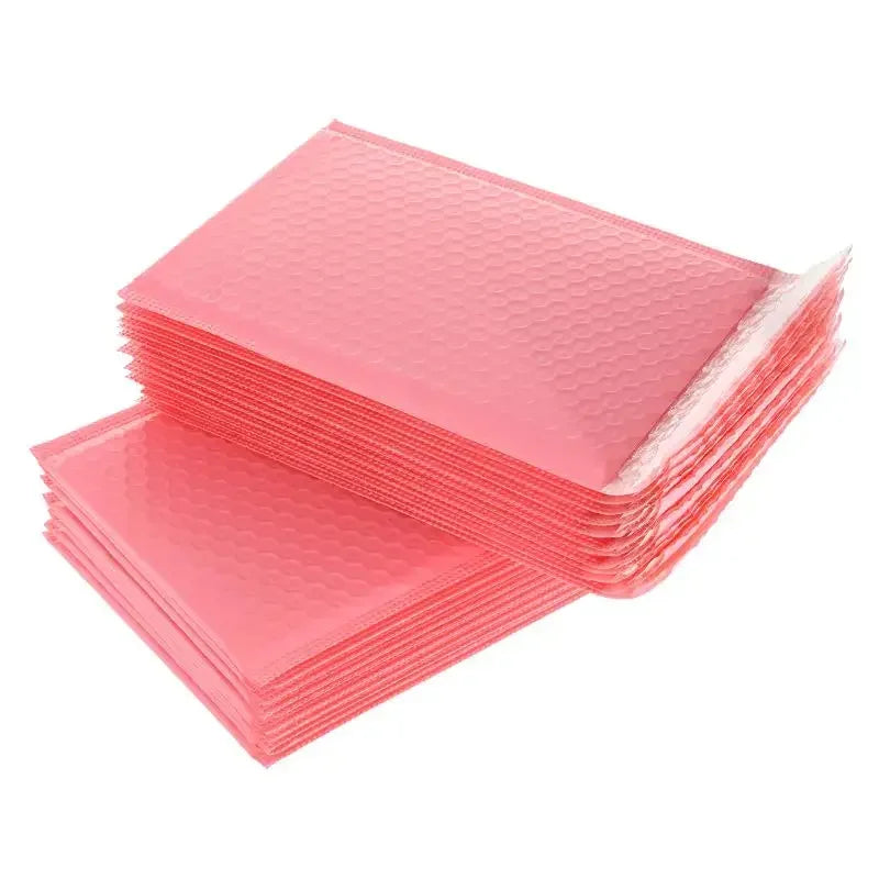 A stack of pink bubble mailers, self-sealing padded envelopes, is shown in a flat lay view.
