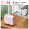 A pink dual-port charging device is shown on a wooden table, demonstrating its power for two devices simultaneously.