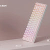 A close-up view of pink crystal clear mechanical keycaps arranged in a row on a white surface.