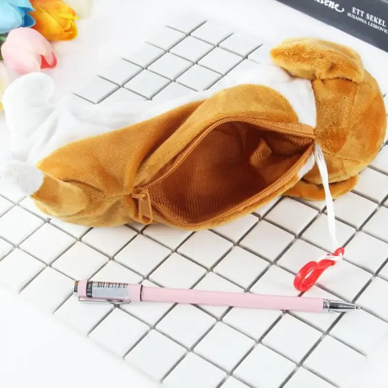 A tan plush dog pencil case with a smooth zipper is shown next to a pink pen on a white grid background.