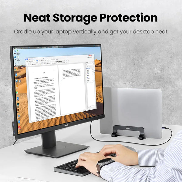 A person is using a vertical laptop stand to prop up a laptop on a desk for neat storage protection.