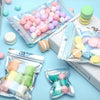 Assortment of pink and purple spherical candies packaged in holographic resealable mylar bags