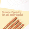 A hand draws smooth lines on paper using various Kissbury micro-pen fineliner pens with archival ink.