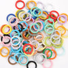 A collection of colorful spring clasps and rings in various shades of red, yellow, green, blue, and white.