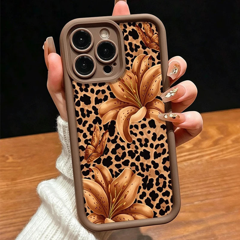 A close-up of a leopard print phone case with large floral designs being held by a hand.