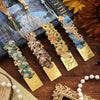 Vintage artistic metal bookmark with tassel featuring floral designs and gold accents.