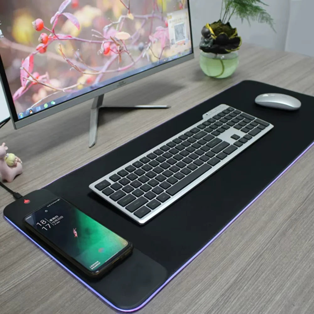 A black mousepad with a built-in light, featuring a keyboard and a smartphone charging area.