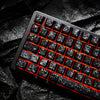 Nahaufnahme einer schwarzen mechanischen Tastatur mit Kohlefaser-Tastenbeleuchtung in Rot.