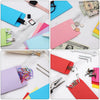 A collection of colorful cash envelopes in various shades including pink, blue, and red, displayed on a white marble surface.