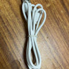 A white charging cable for True Buds 5 Bluetooth 5.3 wireless earphones lying on a wooden surface.