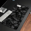 A black gaming desk mat featuring a pattern of stacked, rolled-up cash bills and a white mouse resting on the surface.