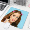 A mouse pad featuring a playful doll face design with pink hair and makeup.