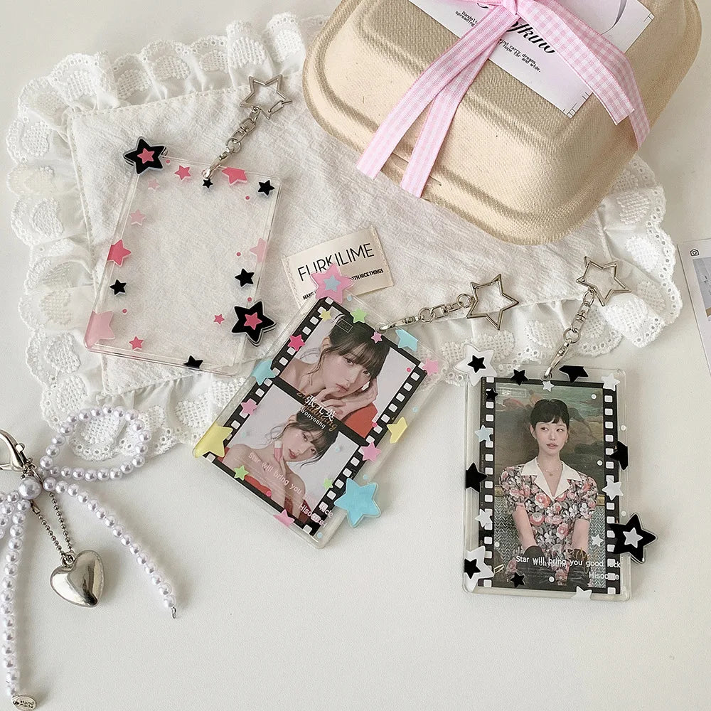 Collection de porte-photos en acrylique et pendentifs avec accents rose et noir, présentés sur une surface blanche.