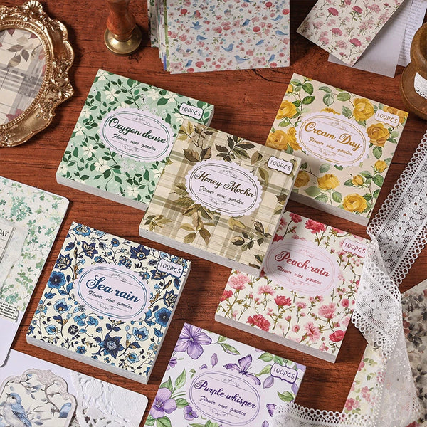 Eine Sammlung von Vintage-Blumendruck-Scrapbook-Papierblättern mit verschiedenen botanischen Designs und gedämpften Farben.
