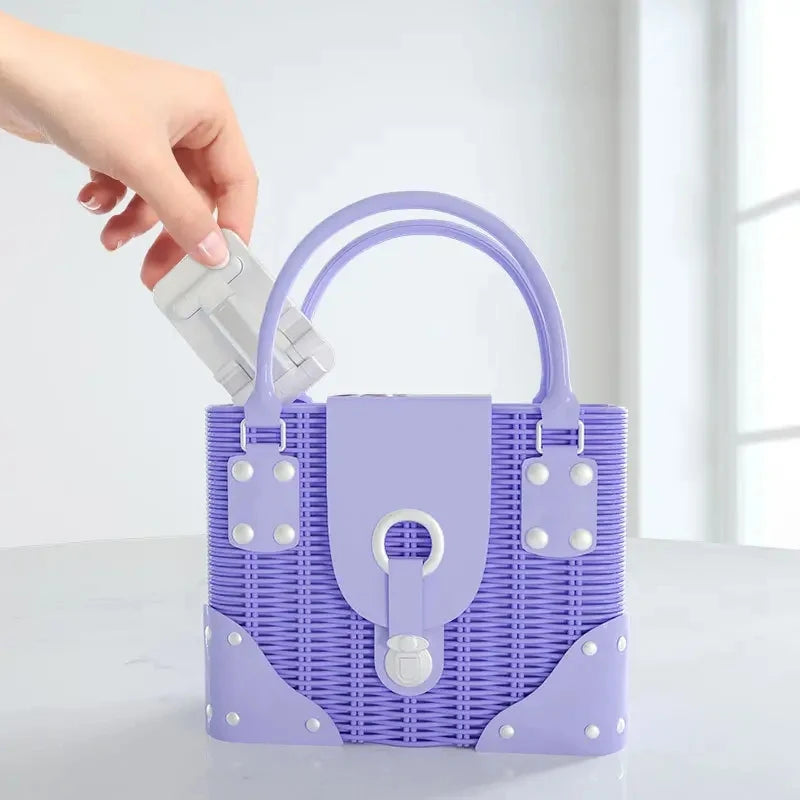 A purple woven desk mount for phones and tablets is being held by a hand.