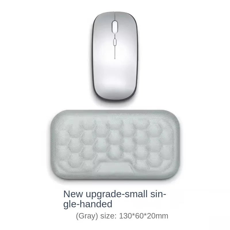 A small gray silicone wrist rest pad for an ergonomic keyboard and mouse.