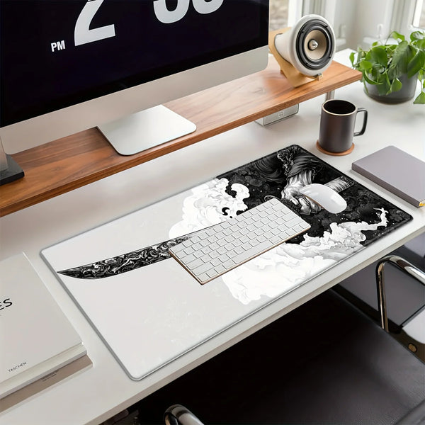 A black and white samurai design oversized gaming mouse pad placed on a white desk next to a computer monitor.