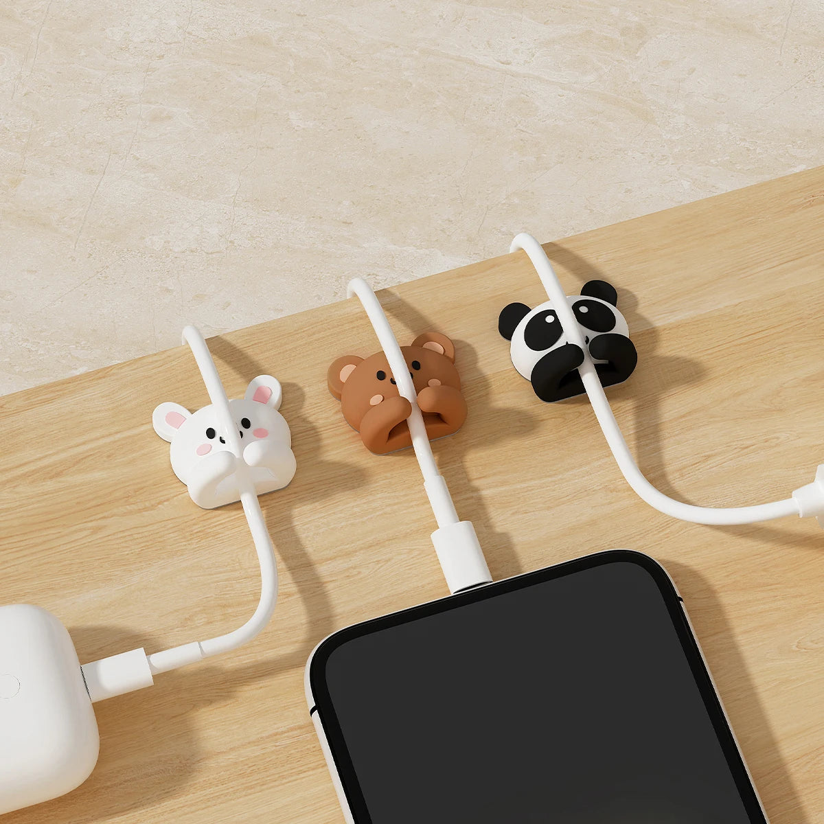 Cartoon desk cable organizers featuring animal shapes like a mouse, bear, and panda on white cords.