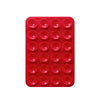 A red silicone phone mount with multiple suction cup holes for mounting devices.