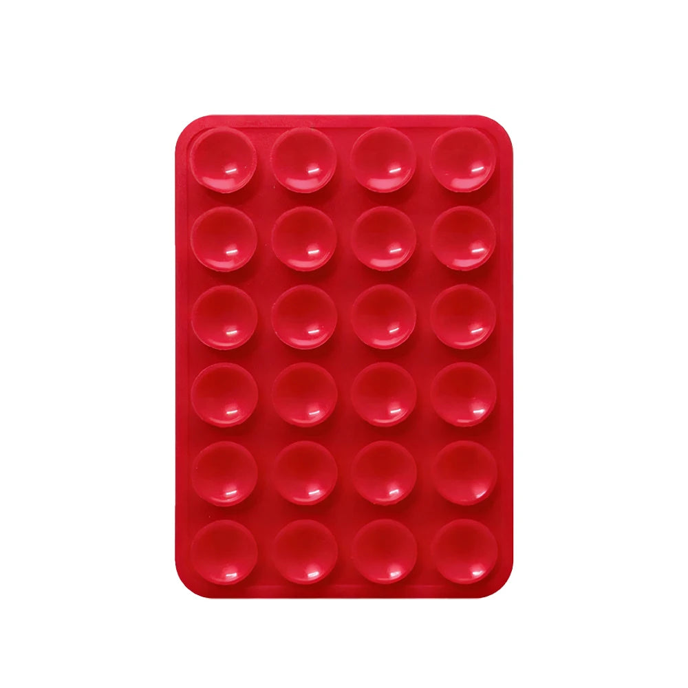 A red silicone phone mount with multiple suction cup holes for mounting devices.