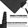 Black desk mat with stitched edges and a magnifying glass showing durable material texture