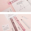 A pink plastic ruler shaped like a cat paw, showing various measurements and markings.