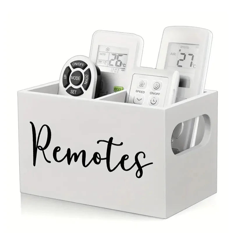 A white wooden storage box with dividers holding several electronic remote controls and small items.
