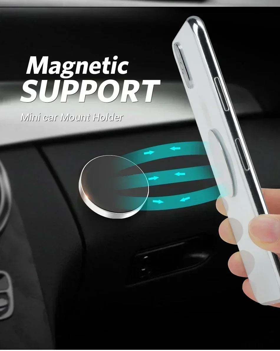 A hand holds a white smartphone attached to a magnetic mount, demonstrating a mini car mount holder for dashboard use.