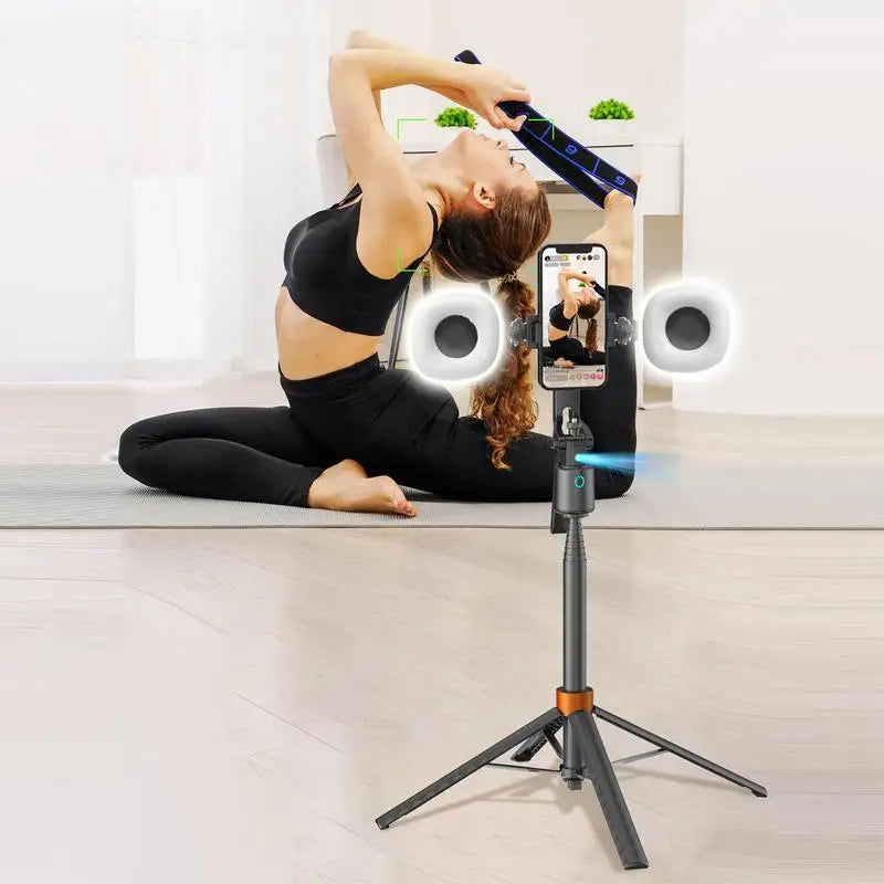 A woman is using a 360° rotatable selfie stick tripod with face tracking and dual light to take a photo.