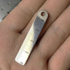 A stainless steel mini ruler with a loop is held in a person's hand, showing the markings 0 through 4.
