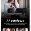 A woman is using a 4K auto-focus webcam for video conferencing, demonstrating its focus capabilities.
