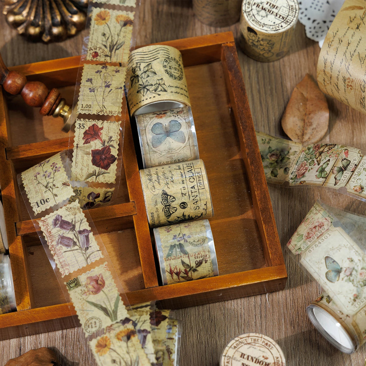 Eine Holzschatulle enthält eine Menge Vintage washi ausgeschnittener Dekopapierbandrollen und einen kleinen Holzstempel.