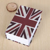 A small book with a British flag pattern cover lying on a wooden surface.