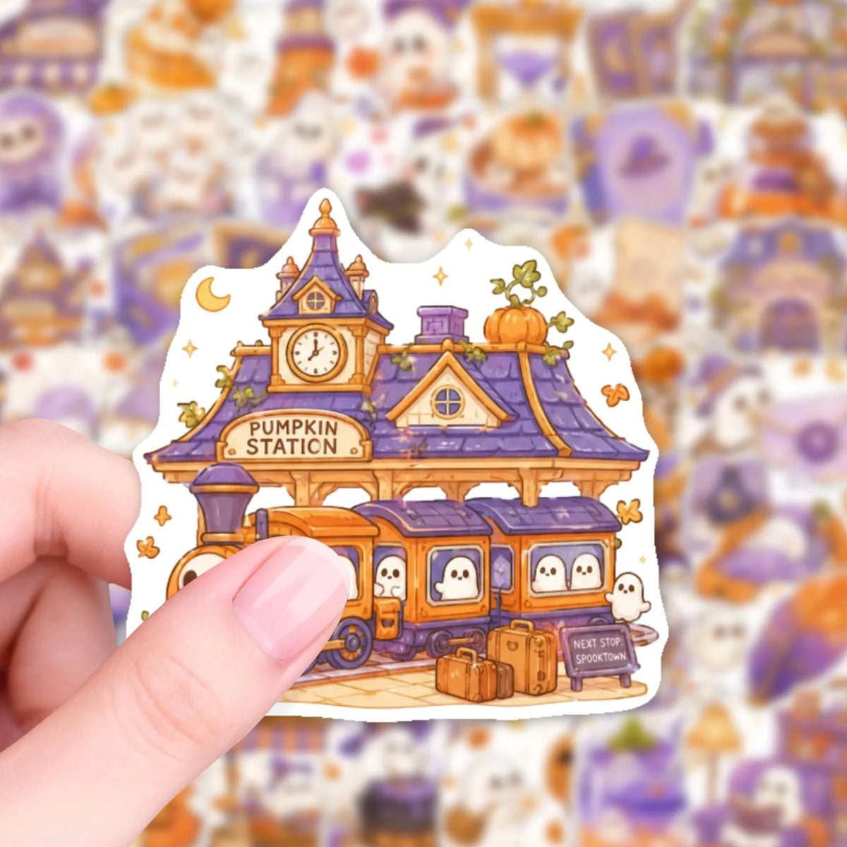 A hand holds a pastel Halloween sticker pack featuring cute ghost, pumpkin, and dessert vinyl decals.