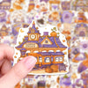 A hand holds a pastel Halloween sticker pack featuring cute ghost, pumpkin, and dessert vinyl decals.