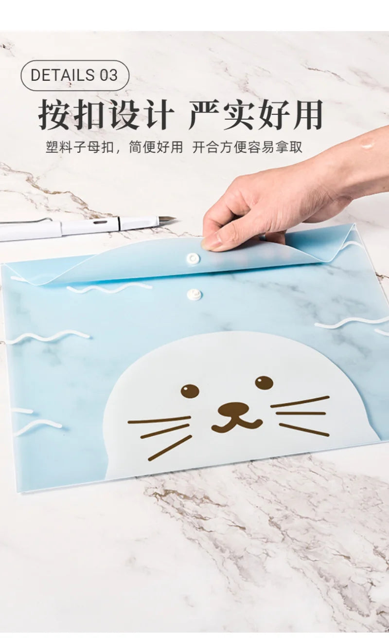 A light blue transparent document pouch featuring a cute cat face design, being held by a hand on a marble surface.
