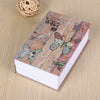 A small notebook featuring illustrations of various butterflies and flowers, placed next to a ball of twine.