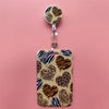 A leopard print card holder clip featuring a textured background with brown and black animal prints.