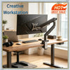 A black adjustable monitor arm is mounted on a wooden desk, positioned above a laptop.