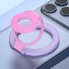 A pink phone ring holder stand with a purple base is shown on a light gray surface.