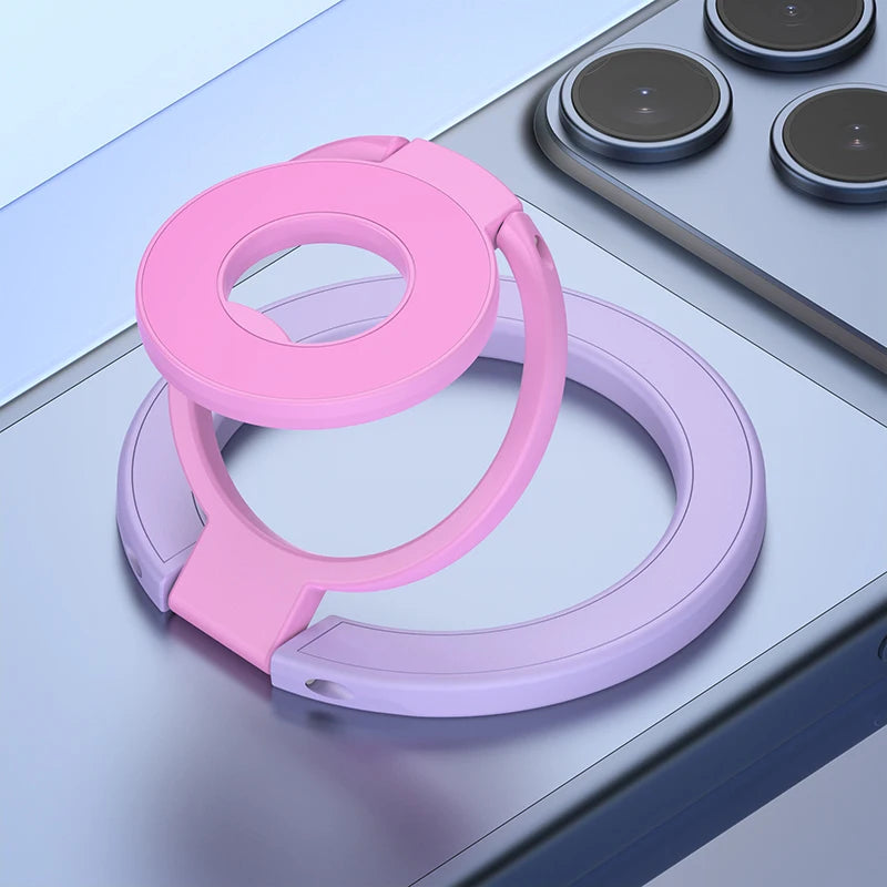 A pink phone ring holder stand with a purple base is shown on a light gray surface.