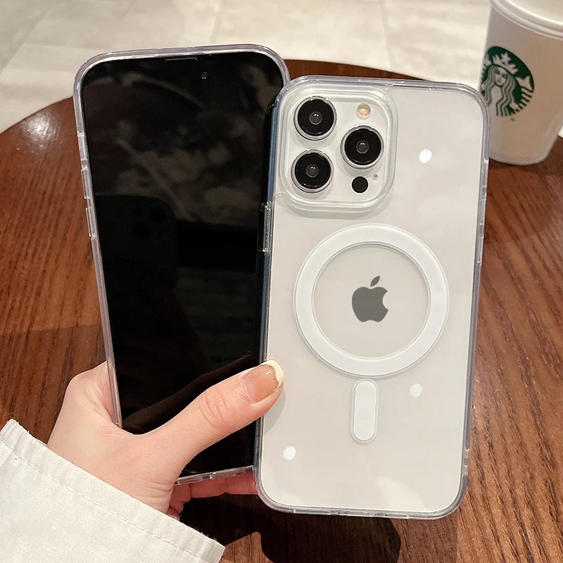 A hand holds a clear magnetic transparent phone case, featuring an Apple-style design, on a wooden surface.