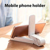 Weißes Handyhalter, um ein Tablet oder Smartphone auf einer Holzoberfläche zu stützen.