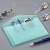 A transparent light blue plastic document folder with a pen and glasses resting on it, next to a roll of patterned tape.